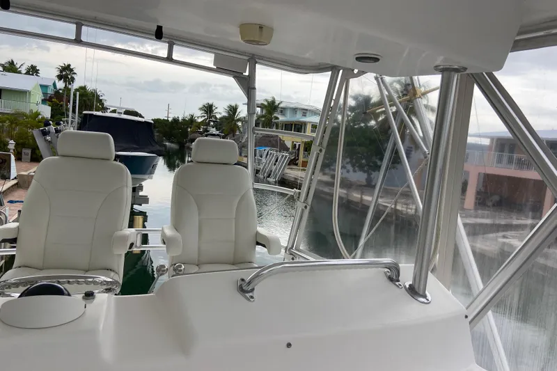Belle La Vie Sur La Mer Yacht Photos Pics Interior view of 2001 Egg Harbor 37 Convertible yacht with white seating and marina backdrop.
