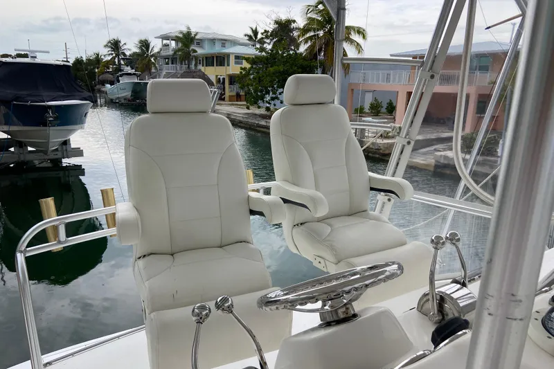 Belle La Vie Sur La Mer Yacht Photos Pics Luxury helm seats on a 2001 Egg Harbor 37 Convertible yacht, docked near waterfront homes.