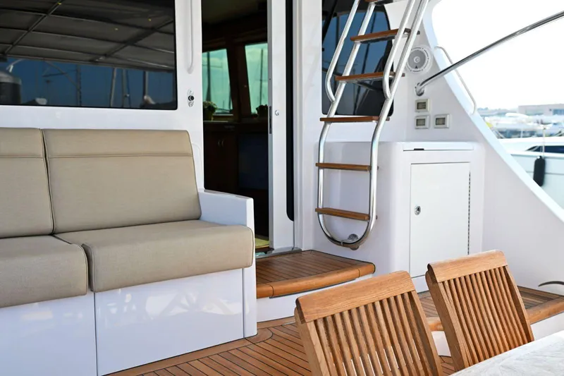 Caraibi Yacht Photos Pics 2013 Hatteras GT63 yacht interior with seating, wooden stairs, and dining area.