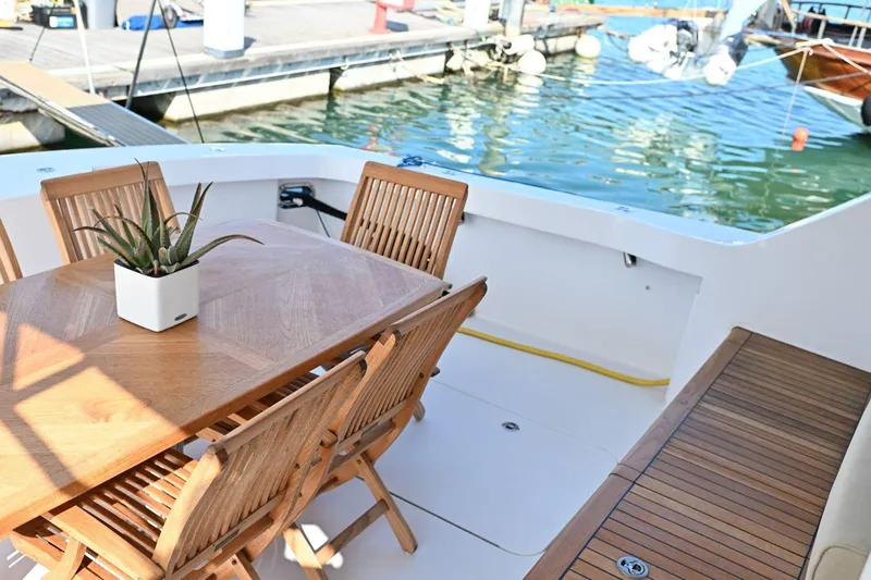 Caraibi Yacht Photos Pics Elegant teak dining area on 2013 Hatteras GT63 yacht, docked at marina.