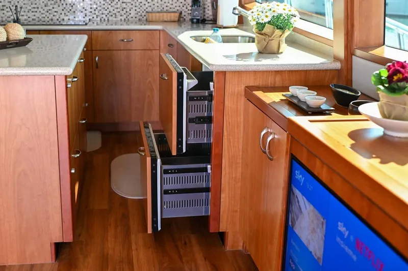 Caraibi Yacht Photos Pics Luxurious kitchen interior of 2013 Hatteras GT63 yacht with wooden cabinetry and modern appliances.