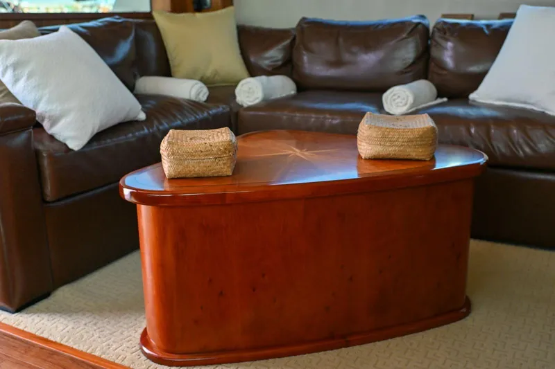 Caraibi Yacht Photos Pics Luxurious interior of 2013 Hatteras GT63 yacht with leather sofa and wooden table.