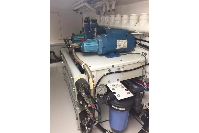 Caraibi Yacht Photos Pics Engine room of 2013 Hatteras GT63 yacht with blue machinery and piping.