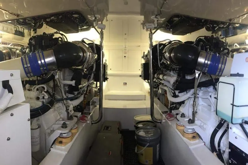Caraibi Yacht Photos Pics Engine room of a 2013 Hatteras GT63 yacht, showcasing dual engines and mechanical components.