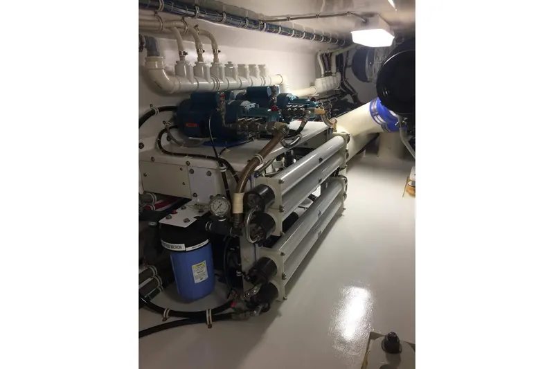 Caraibi Yacht Photos Pics Engine room of 2013 Hatteras GT63 yacht, showcasing mechanical components and piping.