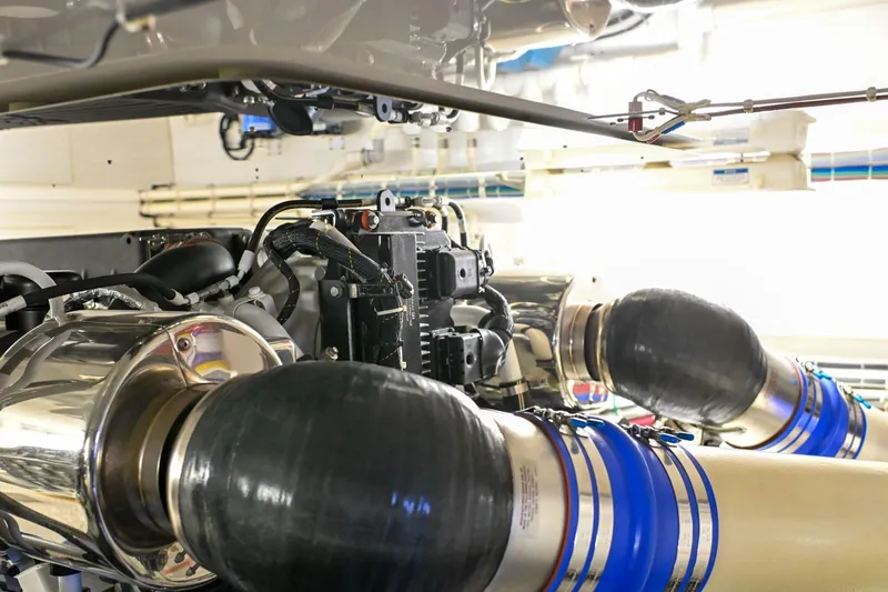 Caraibi Yacht Photos Pics Engine room of a 2013 Hatteras GT63 yacht, showcasing mechanical components and piping.