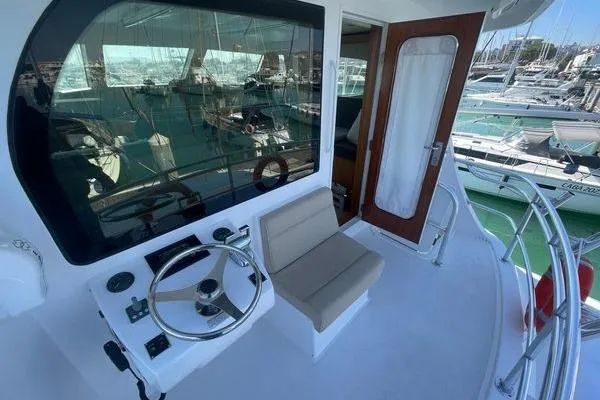 Caraibi Yacht Photos Pics 2013 Hatteras GT63 yacht cockpit with steering wheel and seating, docked at marina.