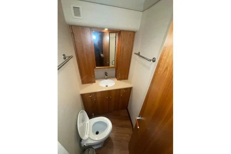 Caraibi Yacht Photos Pics Bathroom interior of 2013 Hatteras GT63 yacht with wooden cabinetry and modern fixtures.