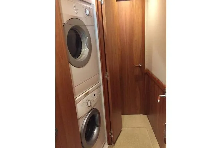 Caraibi Yacht Photos Pics Laundry area inside 2013 Hatteras GT63 yacht with stacked washer and dryer.