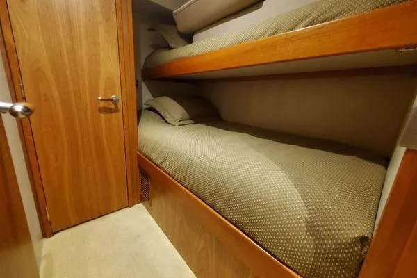 Caraibi Yacht Photos Pics Bunk beds in 2013 Hatteras GT63 yacht cabin with wooden interior.