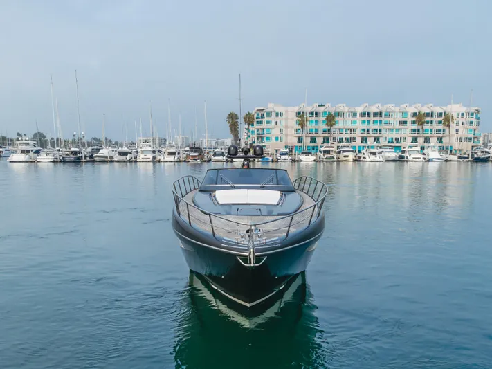 Pergola Yacht Photos Pics 2016 Riva 63 Virtus yacht docked in marina, calm waters, modern waterfront buildings.