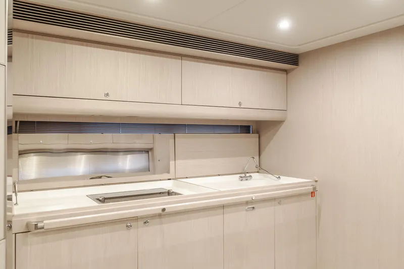 Pergola Yacht Photos Pics Modern kitchen interior of 2016 Riva 63 Virtus yacht, featuring sleek cabinetry and minimalist design.