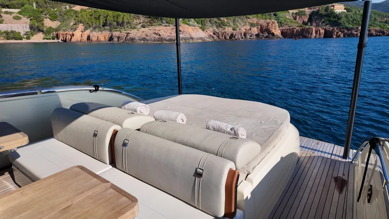  Yacht Photos Pics Luxurious Invictus TT460 yacht deck with sunbathing area, overlooking serene blue waters.