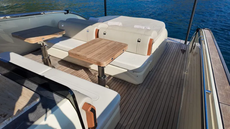  Yacht Photos Pics Luxurious 2020 Invictus TT460 yacht deck with seating and wooden tables, overlooking the water.