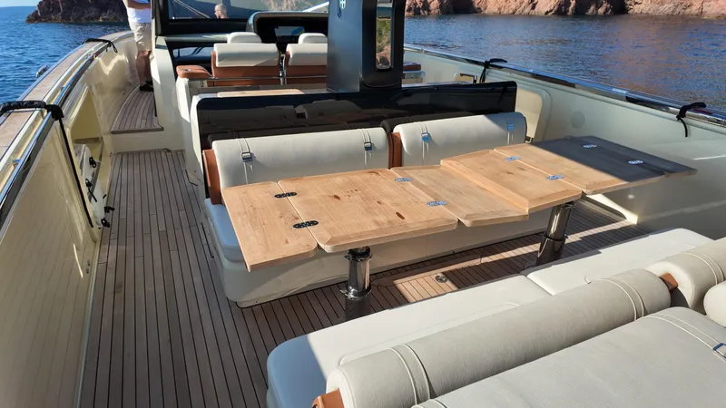  Yacht Photos Pics Luxurious 2020 Invictus TT460 yacht interior with wooden table and seating, docked by scenic waters.