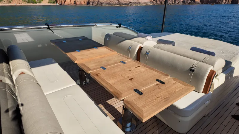  Yacht Photos Pics Luxurious seating area on 2020 Invictus TT460 yacht with wooden table and scenic water view.