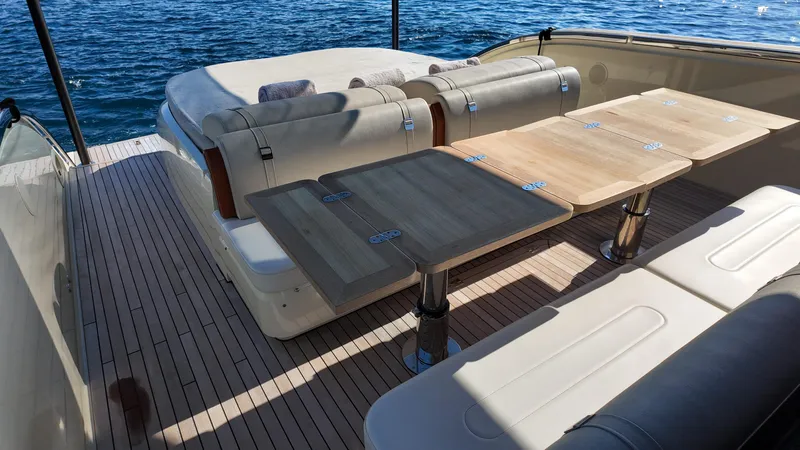  Yacht Photos Pics Luxurious 2020 Invictus TT460 yacht deck with elegant seating and wooden tables, overlooking the ocean.