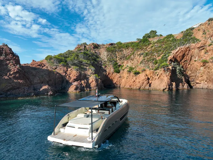  Yacht Photos Pics Invictus TT460 yacht cruising near rocky coastline under blue sky, 2020 model.