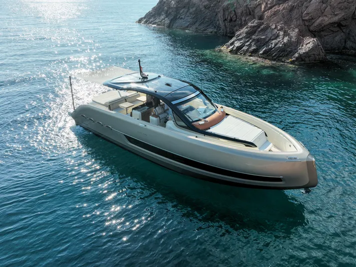  Yacht Photos Pics Luxury Invictus TT460 yacht cruising in clear blue waters near rocky coastline.