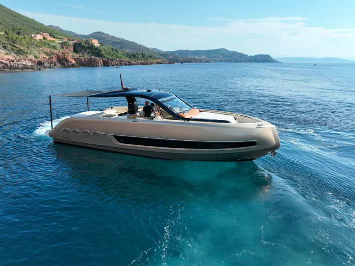  Yacht Photos Pics 2020 Invictus TT460 yacht cruising on clear blue waters near a scenic coastline.