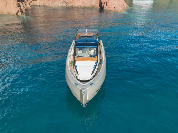  Yacht Photos Pics Invictus TT460 yacht, 2020 model, on clear blue water near rocky coastline.