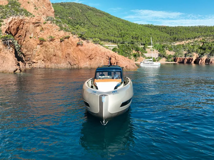  Yacht Photos Pics Invictus TT460 yacht in scenic coastal waters, 2020 model, with rocky cliffs and greenery.