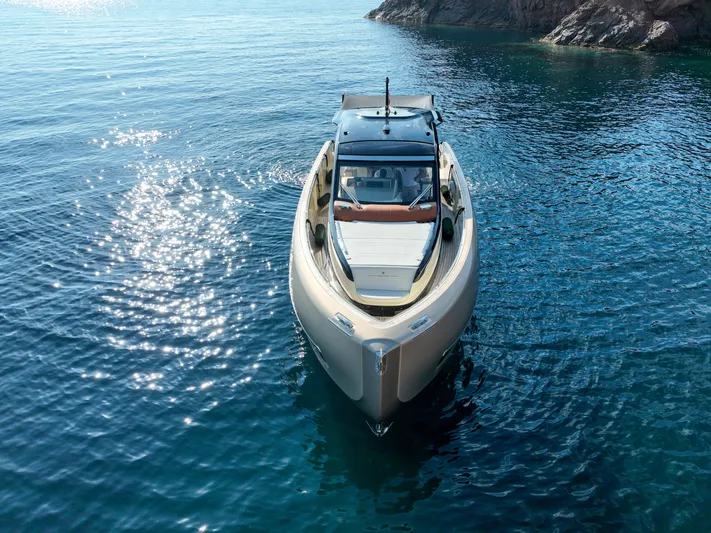  Yacht Photos Pics Invictus TT460 yacht, 2020 model, cruising on clear blue water near rocky coastline.