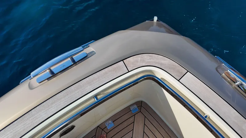  Yacht Photos Pics Invictus TT460 yacht bow, 2020 model, with sleek design and wooden deck, on blue water.