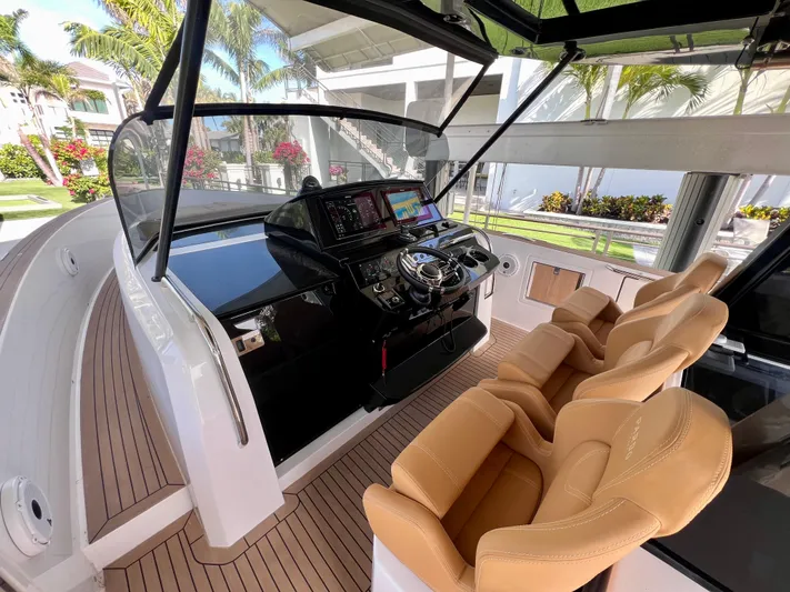  Yacht Photos Pics 2024 Pardo Yachts P38 helm with modern controls and tan seating, docked in a tropical setting.