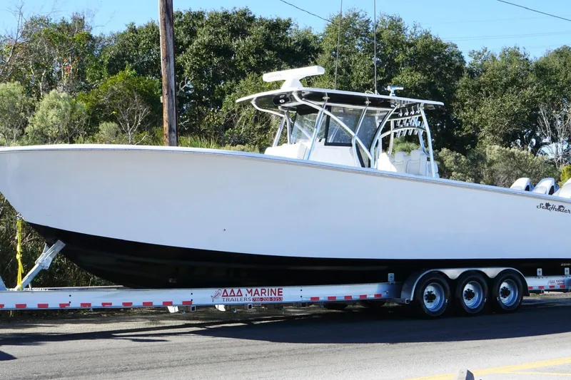  Yacht Photos Pics 2024 SeaHunter 39 Tournament boat on trailer, parked on roadside with trees in background.