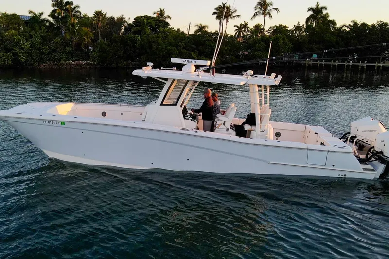  Yacht Photos Pics 2022 World Cat 400 CC-X boat cruising on calm water near lush greenery.