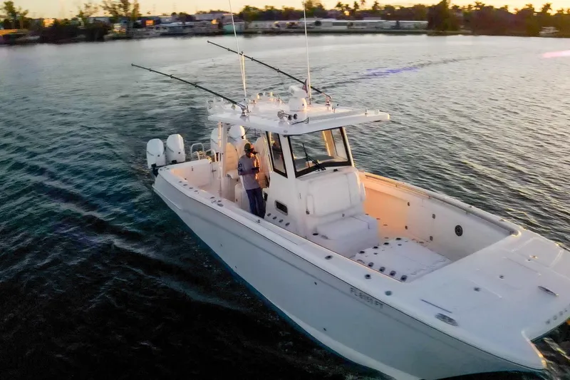  Yacht Photos Pics 2022 World Cat 400 CC-X boat cruising on calm water at sunset.