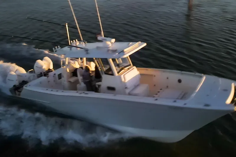  Yacht Photos Pics 2022 World Cat 400 CC-X cruising on water at sunset, showcasing sleek design and powerful engines.