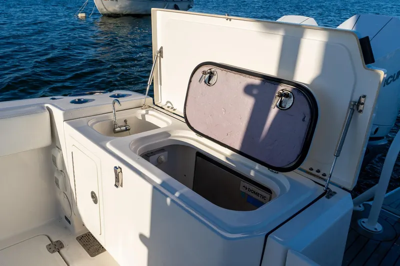  Yacht Photos Pics 2022 World Cat 400 CC-X boat with open storage compartment and sink, on water.