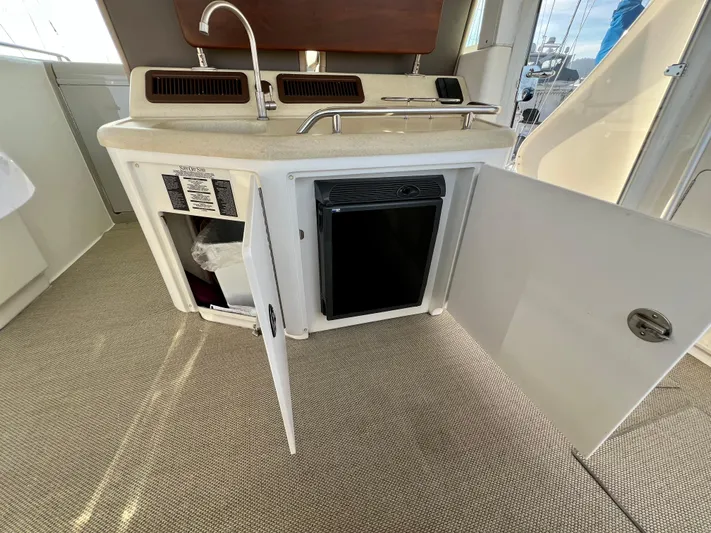 Reflections Yacht Photos Pics 2005 Sea Ray 390 Motor Yacht interior with open cabinet and mini fridge.