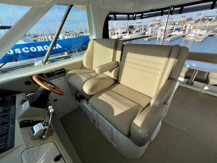 Reflections Yacht Photos Pics 2005 Sea Ray 390 Motor Yacht helm with beige seats, overlooking marina.