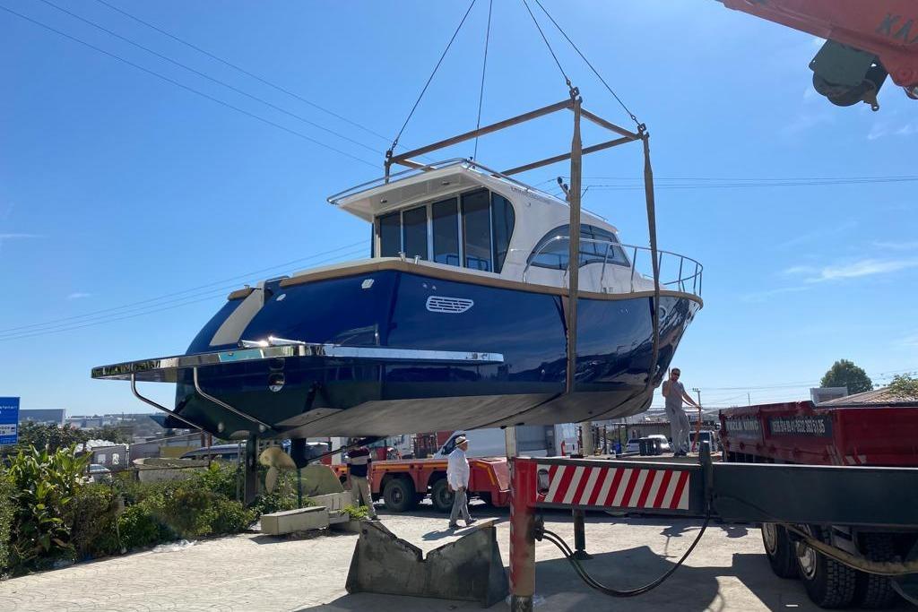 2024 Erman Lobster 34 boat being lifted by crane under clear blue sky.