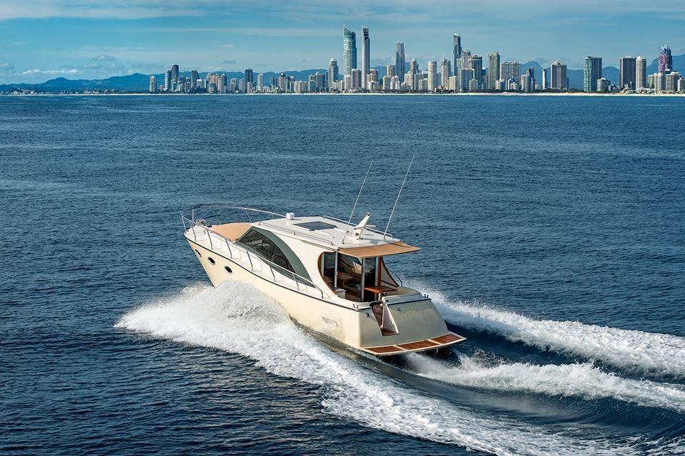 2024 Erman Lobster 34 yacht cruising near a city skyline on a sunny day.