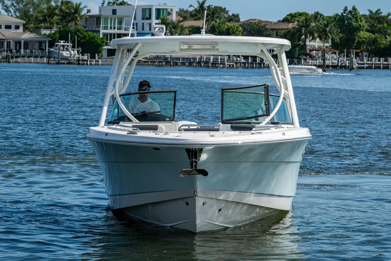  Yacht Photos Pics 2020 Robalo R317 Dual Console boat cruising on a sunny day near waterfront homes.