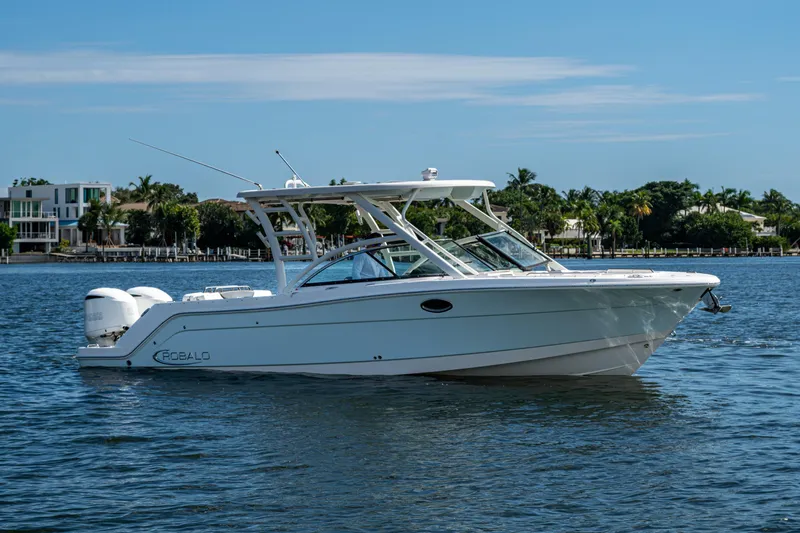 Yacht Photos Pics 2020 Robalo R317 Dual Console boat on calm water, with scenic background.