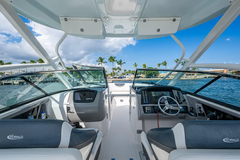  Yacht Photos Pics 2020 Robalo R317 Dual Console boat interior with steering wheel and dashboard, on a sunny day.