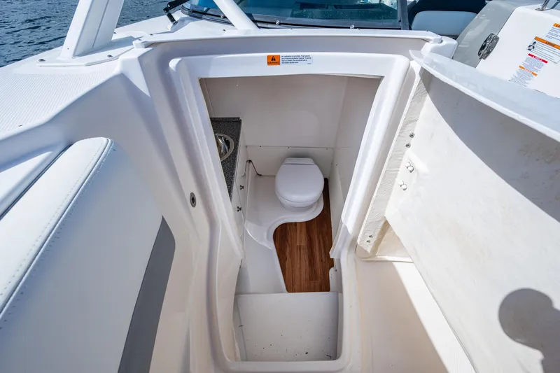  Yacht Photos Pics 2020 Robalo R317 Dual Console boat interior with compact marine toilet.