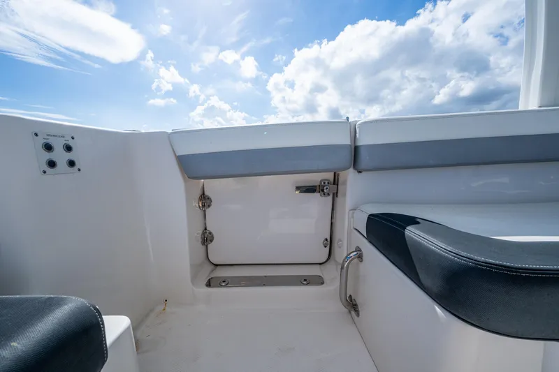  Yacht Photos Pics 2020 Robalo R317 Dual Console boat interior with seating and storage, under a blue sky.