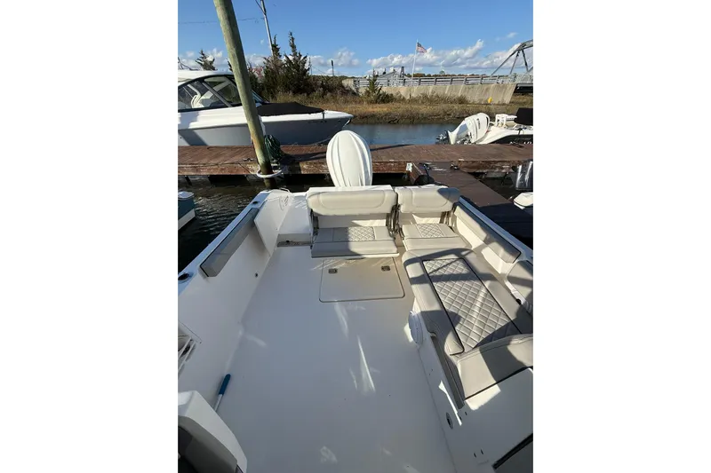  Yacht Photos Pics 2024 Pursuit DC 246 Dual Console boat interior with cushioned seating at dock.