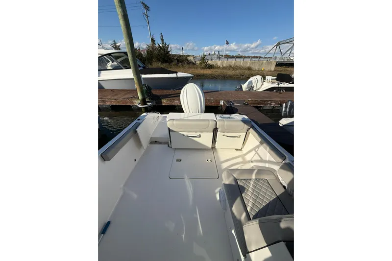  Yacht Photos Pics 2024 Pursuit DC 246 Dual Console boat docked, featuring spacious seating and sleek design.