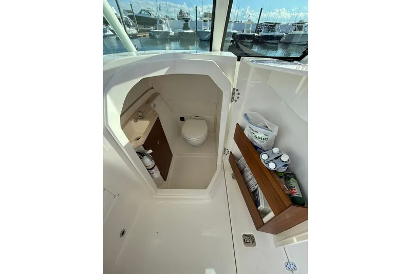  Yacht Photos Pics 2024 Pursuit DC 246 Dual Console boat interior with compact bathroom and storage.