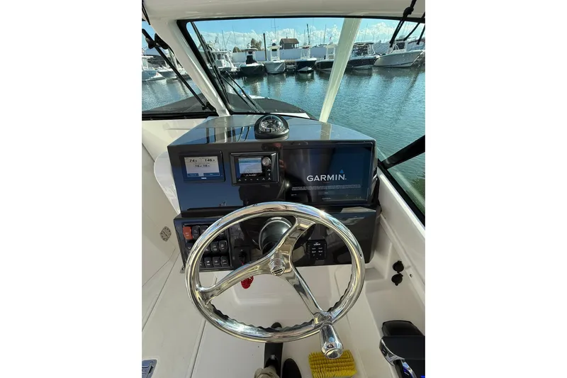  Yacht Photos Pics 2024 Pursuit DC 246 Dual Console helm with Garmin navigation system, docked at marina.