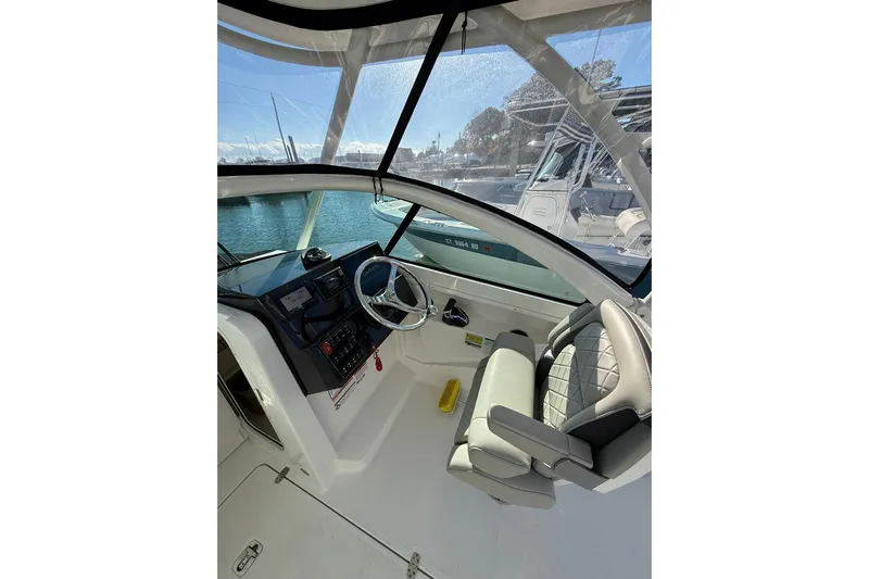  Yacht Photos Pics 2024 Pursuit DC 246 Dual Console boat interior with steering wheel and seating.
