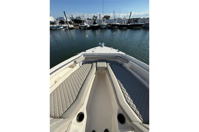  Yacht Photos Pics 2024 Pursuit DC 246 Dual Console boat interior with cushioned seating, docked at marina.
