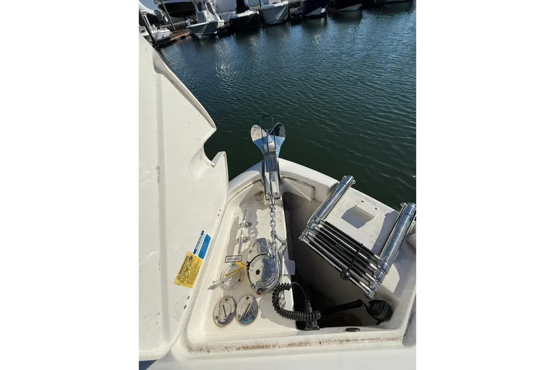  Yacht Photos Pics 2024 Pursuit DC 246 Dual Console boat anchor and ladder setup by the water.